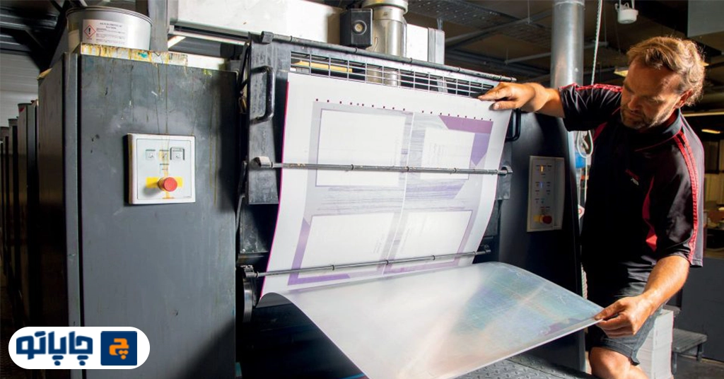 آقا در حال کار با دستگاه چاپ افست